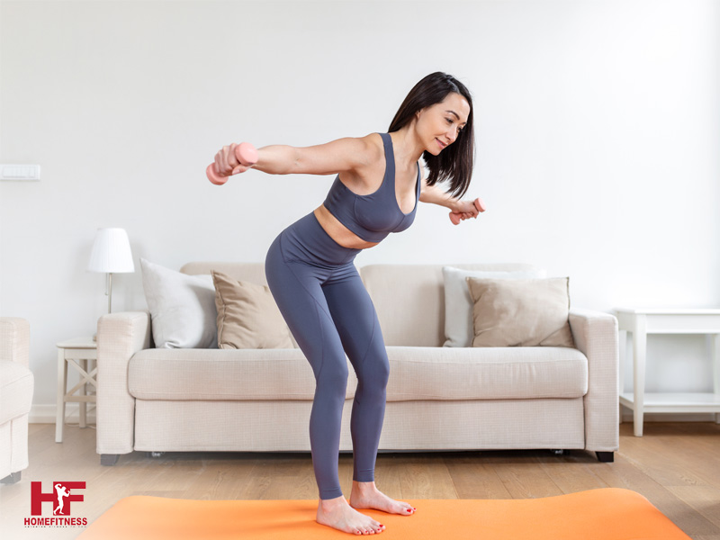 woman using dumbbells and exercise mat for her home workout in singapore